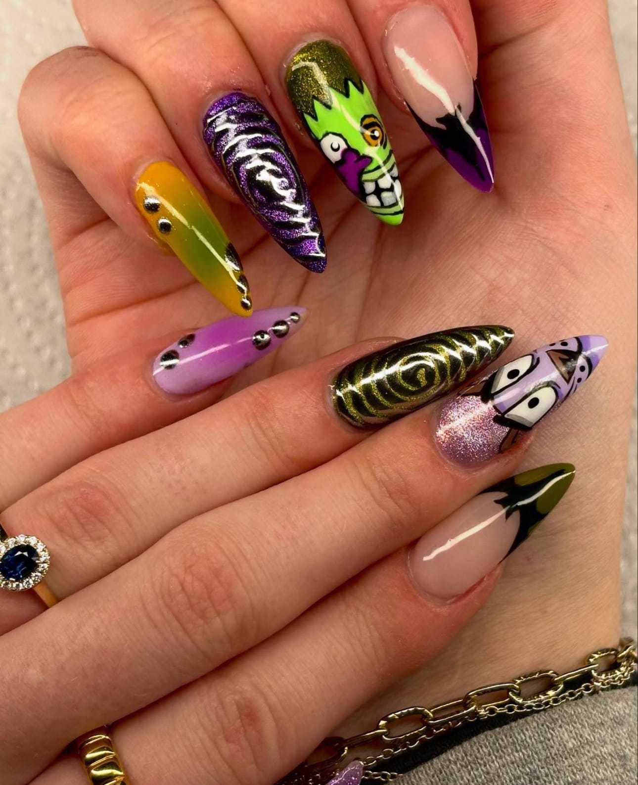 Colorful Halloween-themed nail art with spooky designs on long acrylic nails.